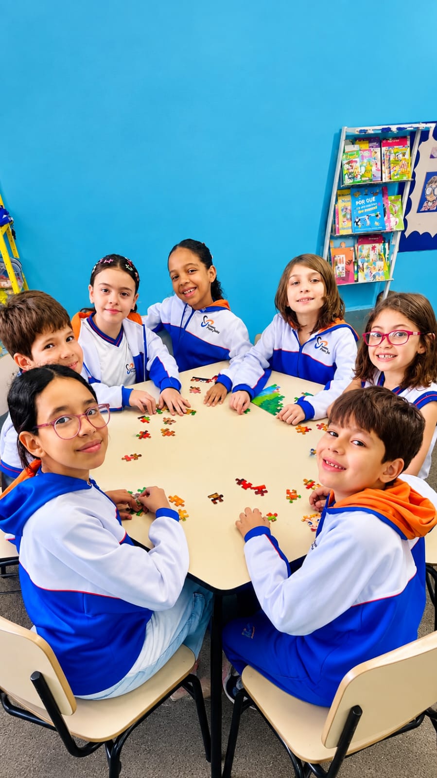 Estudantes reunidos ao redor de uma mesa durante uma atividade em grupo.